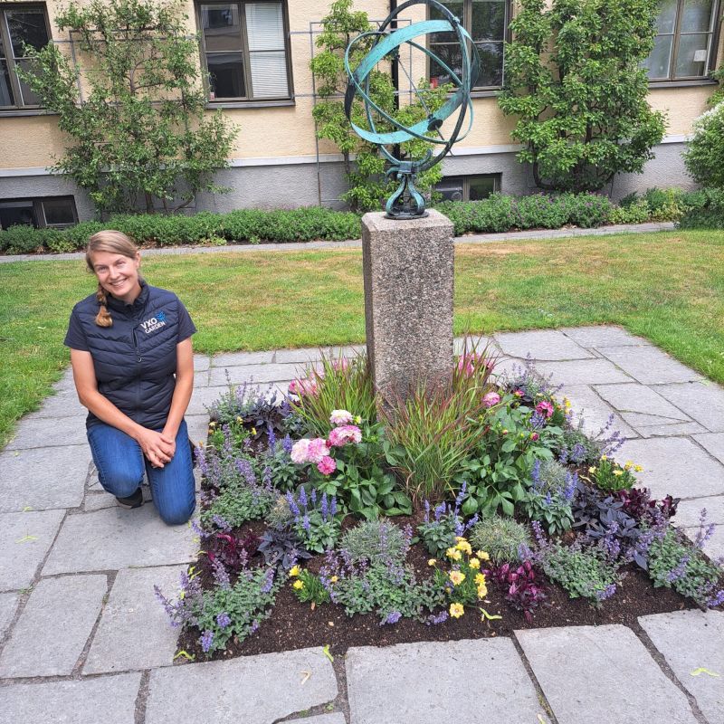 Charlotta framgör plantering framför Residenset i Växjö.