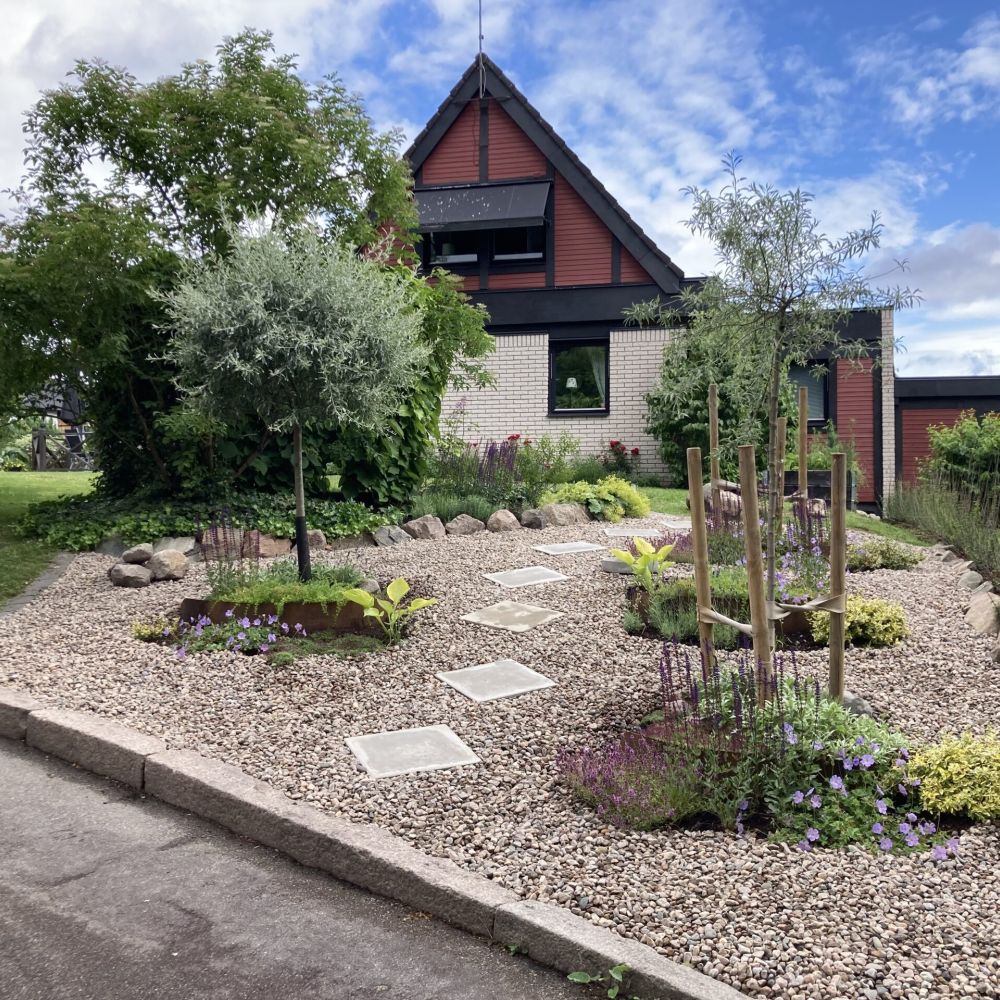 Planteringar framför ett tegelhus.