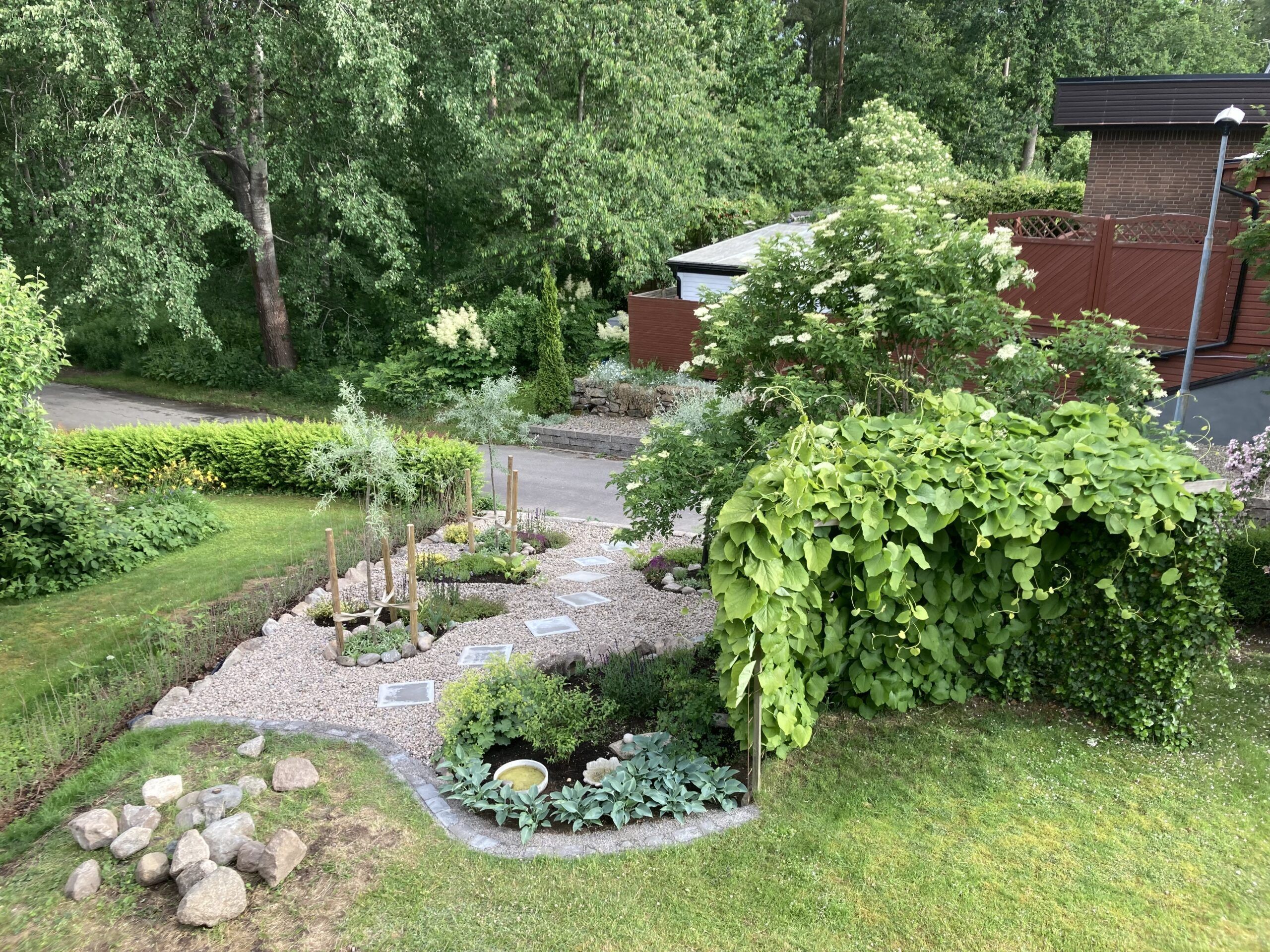 Slänt med frodande växter och planteringar.